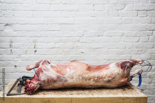 A whole lamb carcass on a butcher's block ready for butchering.  photo