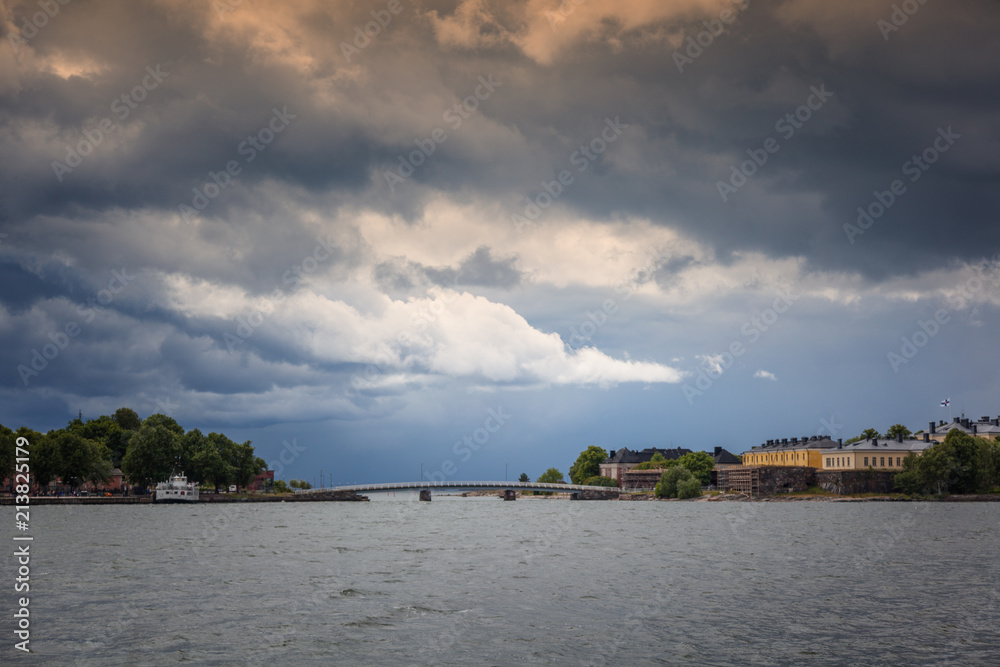 Travel to Finland, view of the island Suomenlinna from the water. Beautiful landscape with the bright cloudy dramatic stormy sky