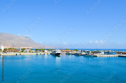 A wharf in a small Greek port in the early morning. Pleasure boats and buses in a small port