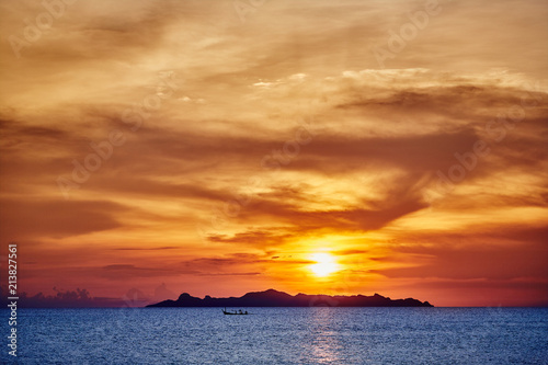 Blue sea against red sky during sunset with silhouette island