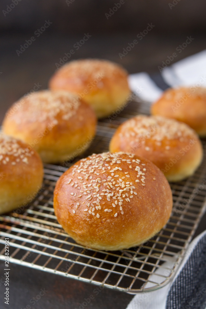 Homemade Hamburger Buns Topped with Sesame Seeds on a Rustic Black Background Homemade Hamburger Buns Topped with Sesame Seeds on a Rustic Black Background