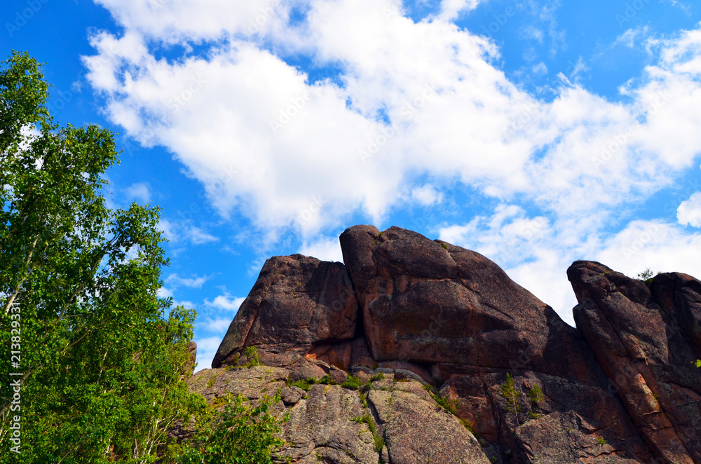 Rocks on a blue sky background. Mountains. Beautiful scenery. Ascent. Hiking in the mountains. Krasnoyarsk. Taiga. Mountains in the forest. Siberia.