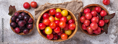 Various type of cherry-plum in wooden bowls 