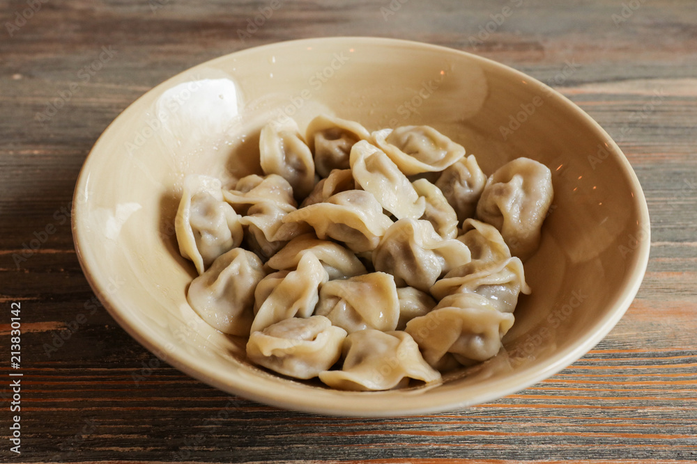 Boiled dumplings on a ceramic plate on a table Boiled dumplings on a ceramic plate on a table