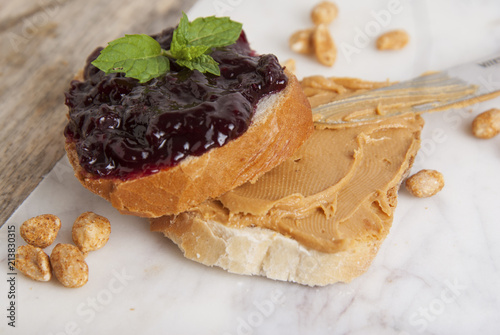 Peanut butter and raspberry jelly sandwich on white background. Sweet breakfast or snack. Close up.
