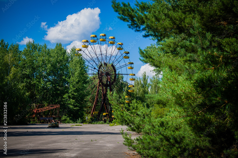 Abandoned famous amusement park surrounded with trees in a ghost town Pripyat, Ukraine, devastated after a disaster at Chernobyl nuclear power plant