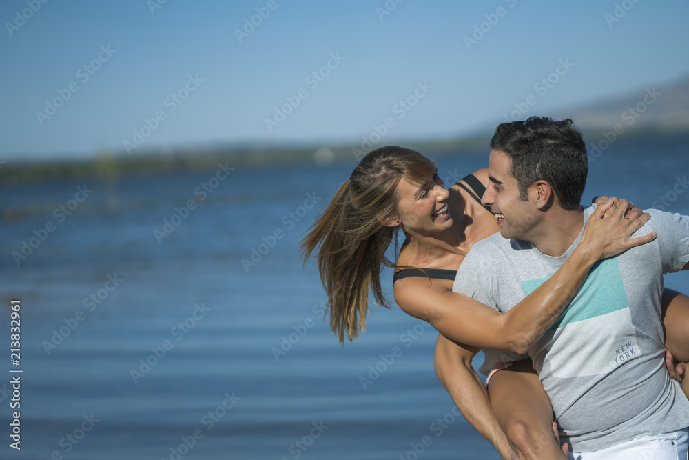 Romantic couple playing outdoors by the lake Romantic couple playing outdoors by the lake