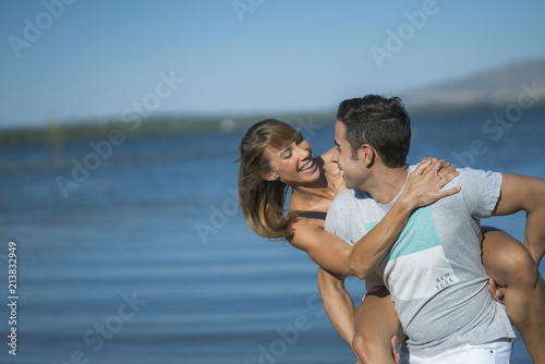 Romantic couple playing outdoors by the lake © karrastock