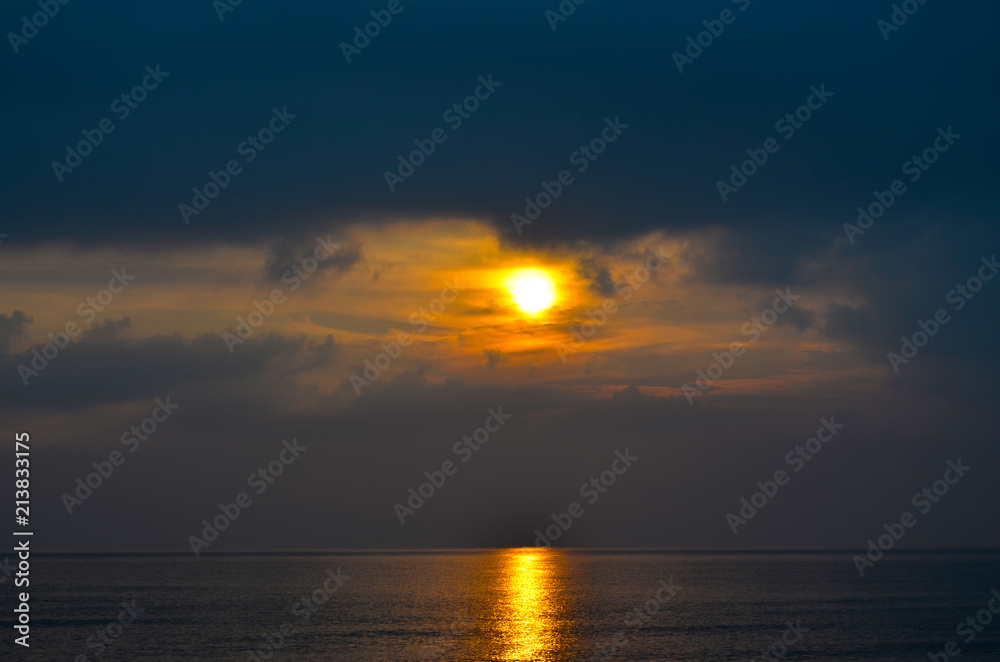 Dramatic light mood with orange illuminated clouds and the sun as a fiery ball during a sunrise over the Baltic Sea in Bansin on usedom, Germany