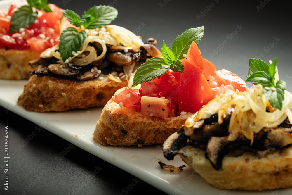 Fresh bruschetta assorted. Serve on a white plate. Order in the menu Fresh bruschetta assorted. Serve on a white plate. Order in the menu
