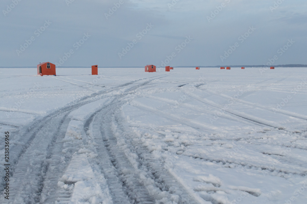 Ice fishing huts on a frozen lake in Ontario at sunset Ice fishing huts on a frozen lake in Ontario at sunset