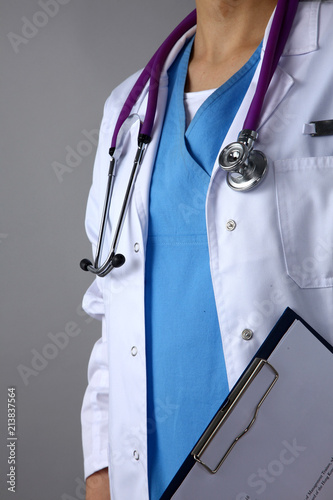 Female doctor standing with a folder , isolated on gray background