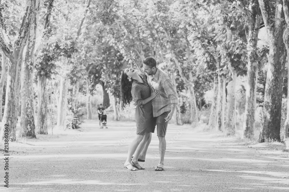 Fototapeta premium young pretty couple dancing in a green park