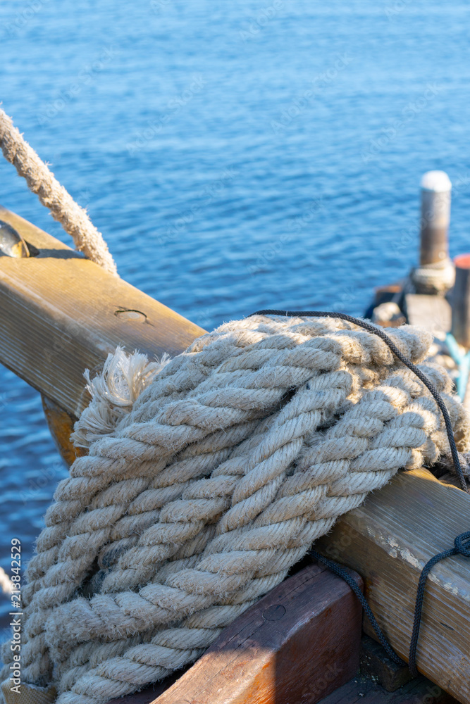 A rolled thick rope aboard an ancient wooden ship. Stock Photo
