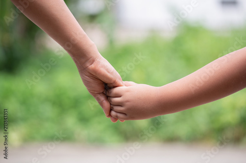 hand of parent and child on the background blurred nature.Mother holding hands baby © photosky99