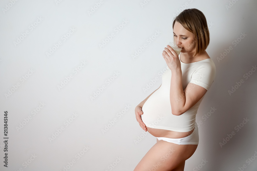 Fototapeta premium pregnant girl laughing on a white background