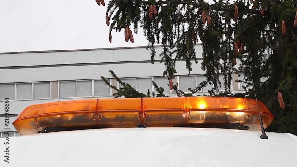 Detalle de luces de emergencia de color naranja o rotativas encendidas en el techo de una ambulancia
