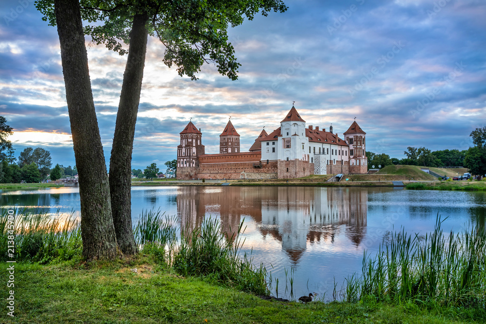 Mir Castle reflecting in water in the evening, Belarus