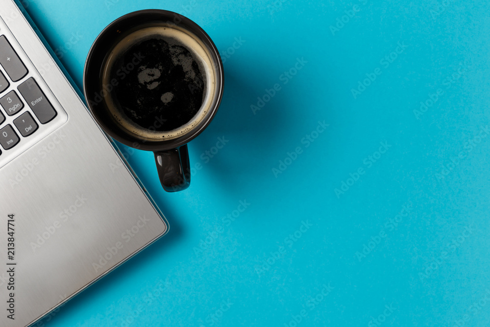 Minimal workspace with Laptop and coffee Cup copy space on blue background. Top view. Flat lay style. Minimal workspace with Laptop and coffee Cup copy space on blue background. Top view. Flat lay style.