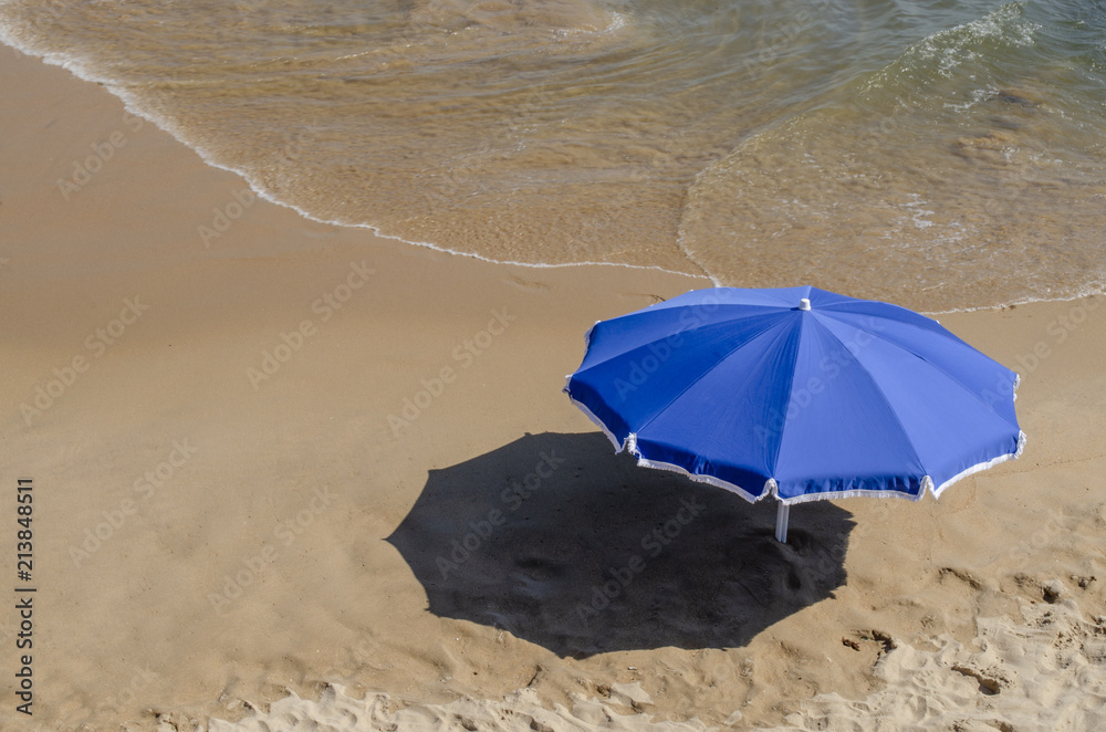 sombrilla azul en la playa a la orilla del mar sombrilla azul en la playa a la orilla del mar
