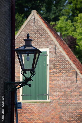 Street lamp, window with green blinds and red roof