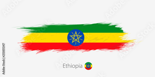 Flag of Ethiopia, grunge abstract brush stroke on gray background.