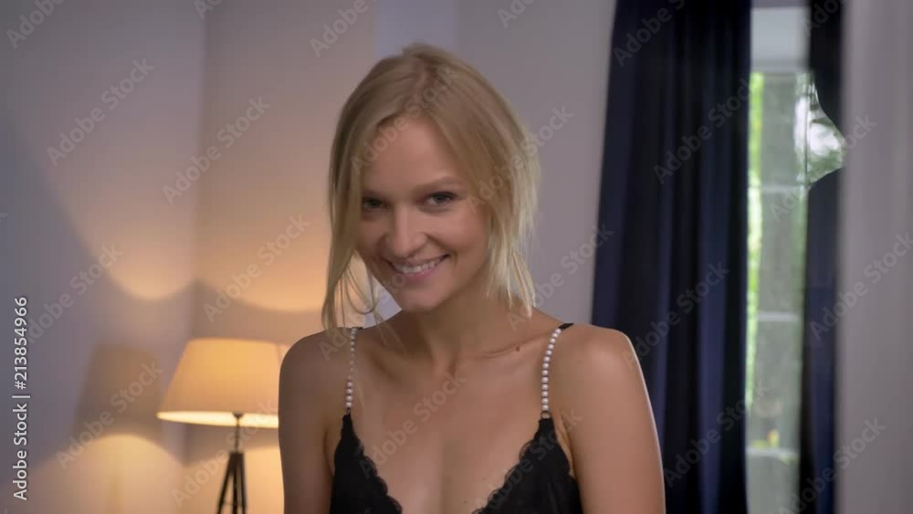 Young sexy blonda lady in lingerie is standing in front of mirror, smiling, flirt concept Young sexy blonda lady in lingerie is standing in front of mirror, smiling, flirt concept