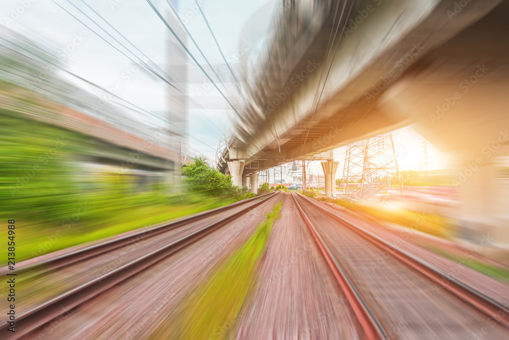 Naklejka premium View of railway tracks motion blur and highway bridges at sunset.