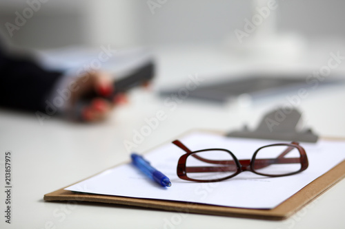 Young woman sitting at the desk with folder