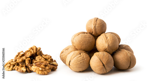 A bunch of walnuts in a peel and a bunch of peeled on a white, isolated.