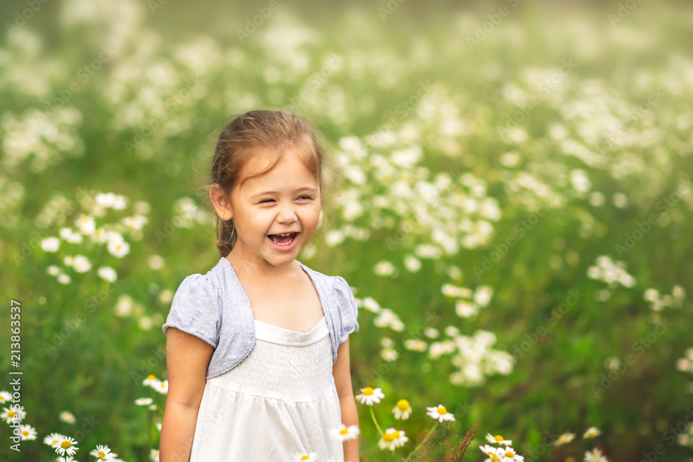 little girl laughing at the meadow of daisies
little girl laughing at the meadow of daisies