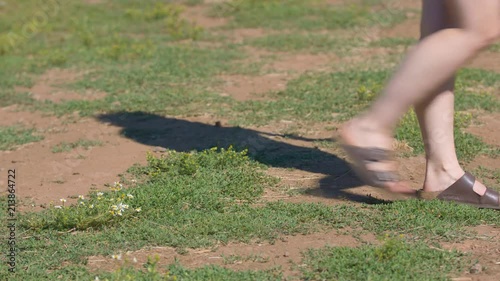 Slow-motion footage of a woman walking past a small patch of daisies.  Shot on a Blackmagic Ursa Mini Pro 4.6k with a Sigma 50-100mm f/1.8.