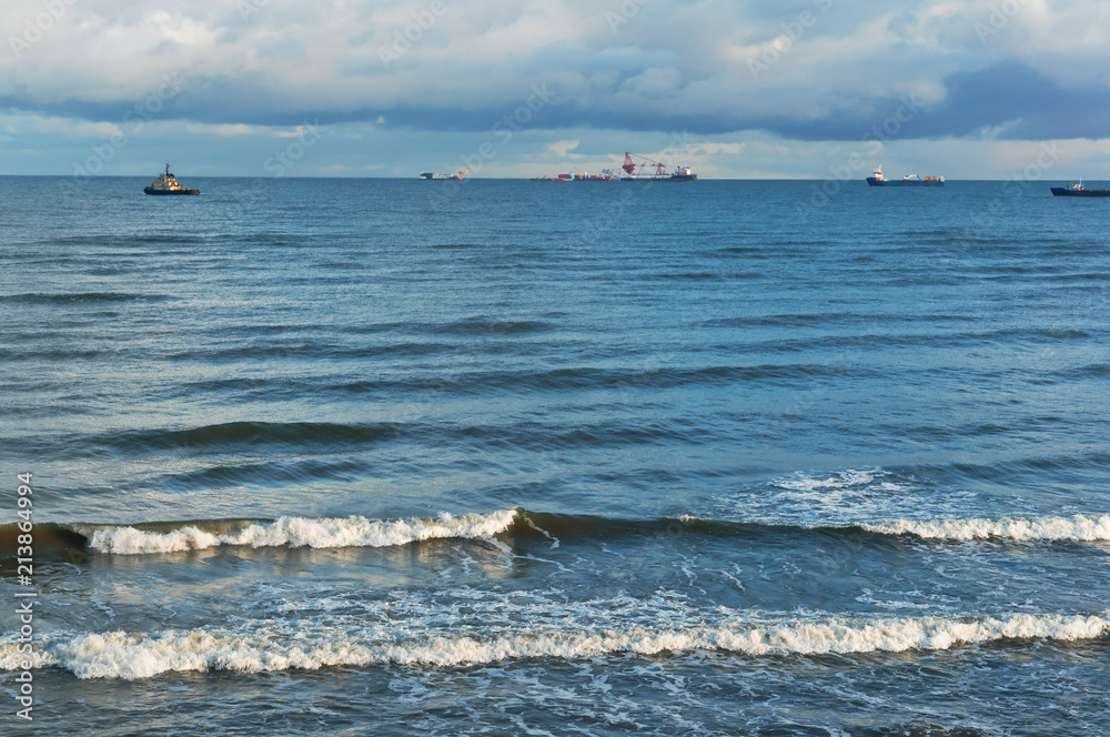 Oil and gas installations in the sea. Sea waves and clouds in the sky.