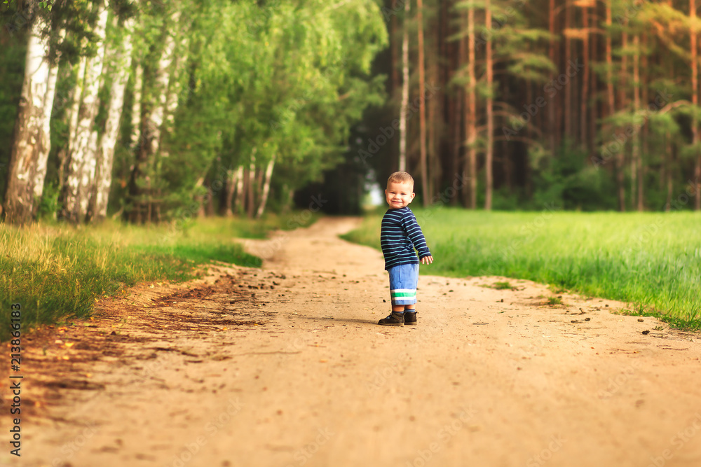 small laughing boy runs along the forest road
small laughing boy runs along the forest road