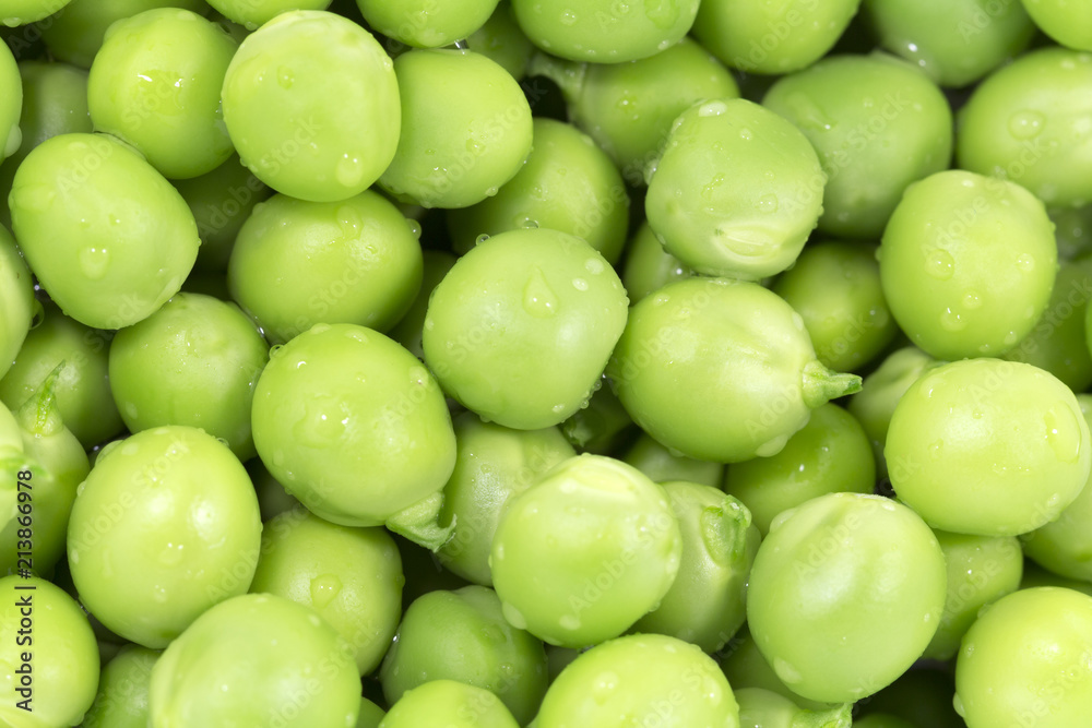 Green peas macro close up background. Horizontal photo of many peeled pea lying on the surface Green peas macro close up background. Horizontal photo of many peeled pea lying on the surface
