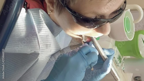 Woman at the dentist clinic office gets dental medical examination and treatment. Odontic and mouth health is important part of modern human life that dentistry help with. Vertical format video. photo