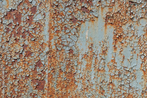 painted iron surface with a large rusty and metal corrosion, chipped paint, old background with peeling and cracking paint, texture