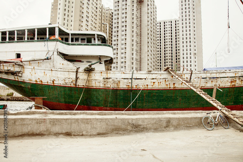 Traditional Indonesian phinisi boat docking at Sunda Kelapa old Jakarta port photo