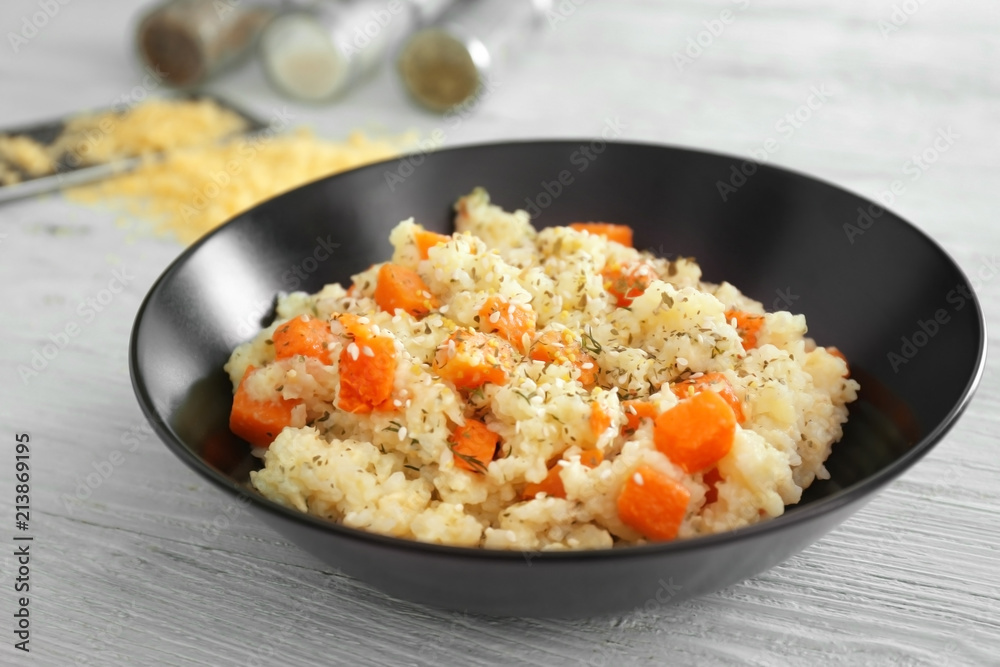 Bowl with delicious pumpkin risotto on wooden table Bowl with delicious pumpkin risotto on wooden table