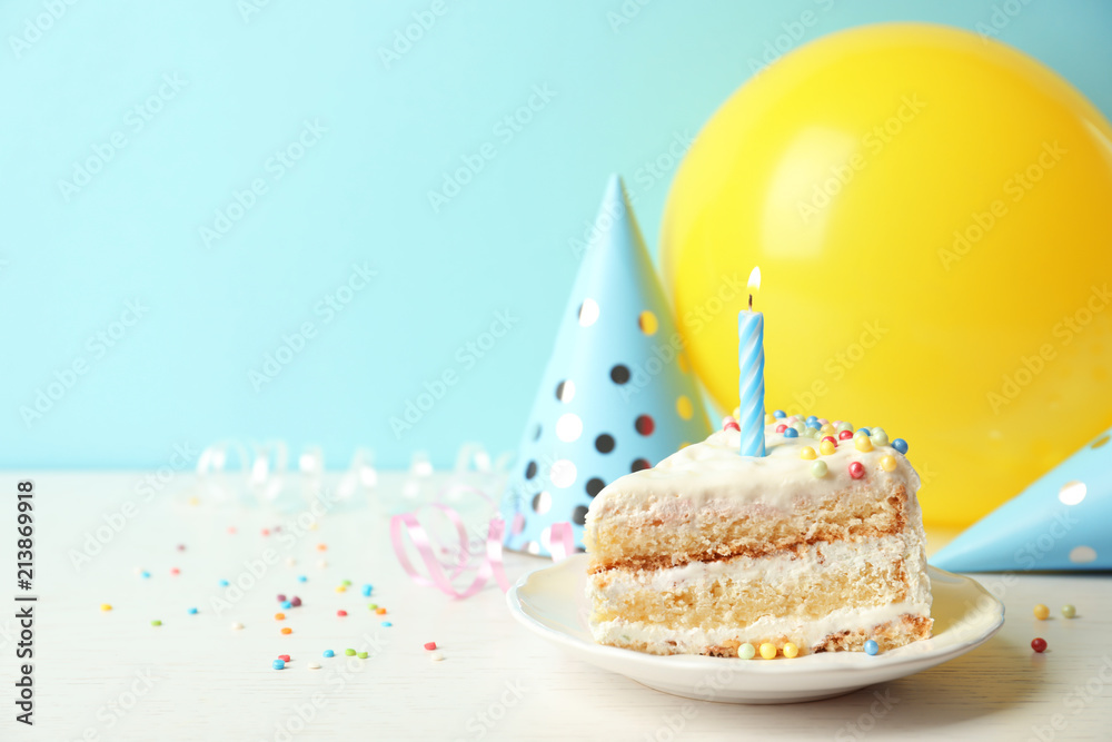 Slice of delicious birthday cake with candle on table Stock Photo ...