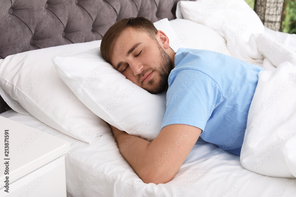 Young handsome man sleeping in bed at home. Early morning Young handsome man sleeping in bed at home. Early morning