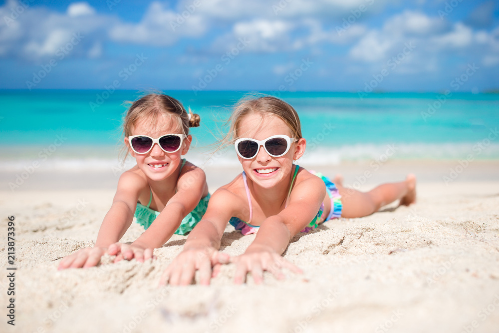 Happy kids lying on warm white sandy beach Happy kids lying on warm white sandy beach