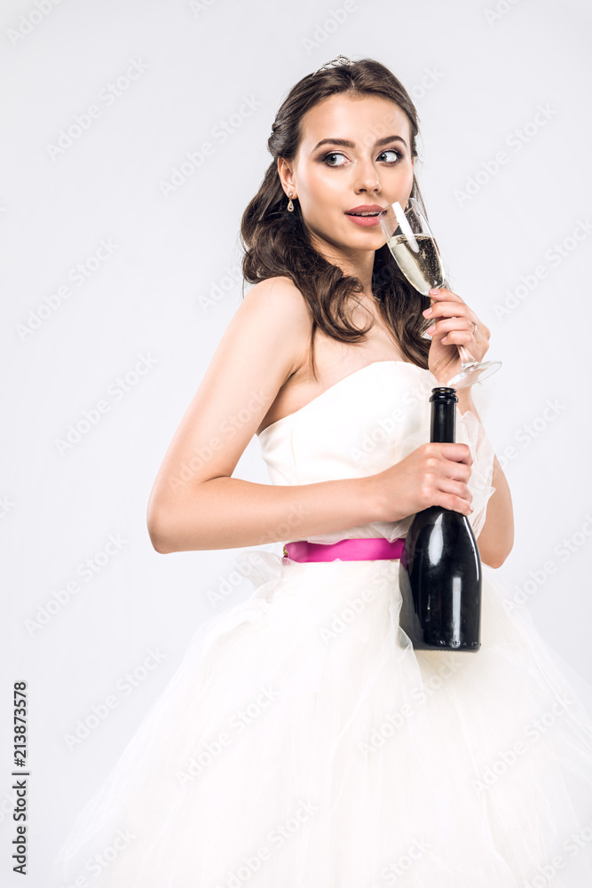 attractive young bride in wedding dress with bottle and glass of champagne isolated on white attractive young bride in wedding dress with bottle and glass of champagne isolated on white