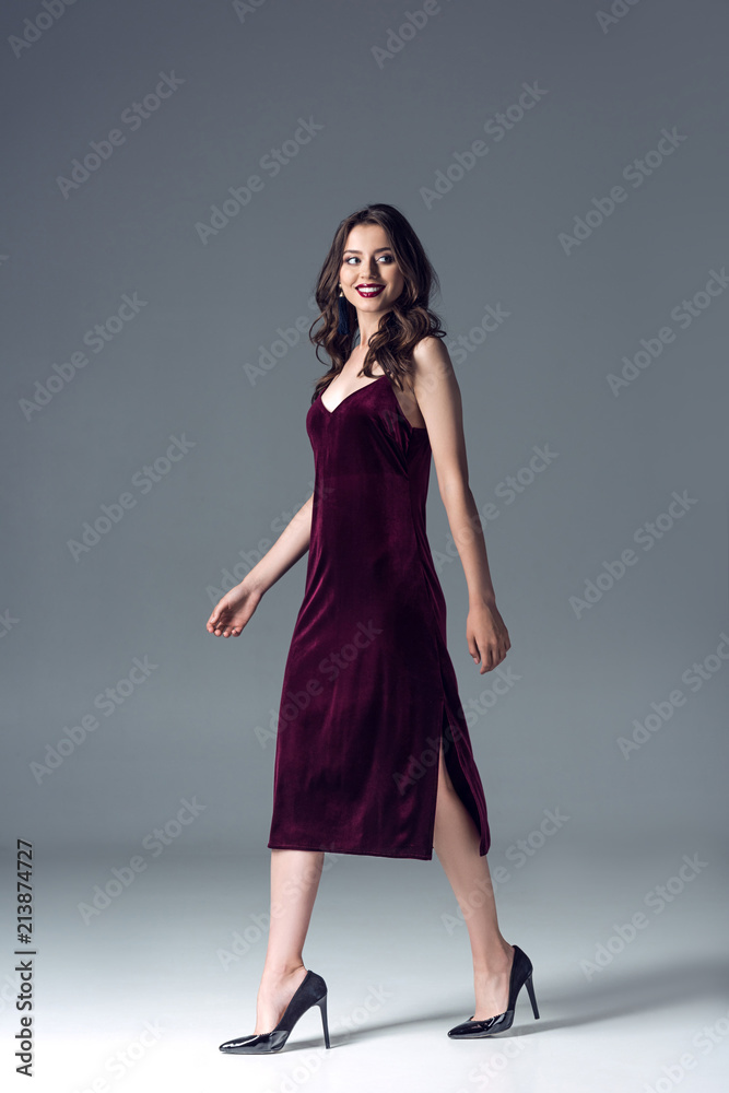 beautiful young woman in stylish dress and high heels walking on grey beautiful young woman in stylish dress and high heels walking on grey