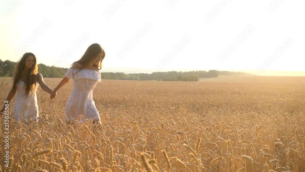 Two girls running on wheat field together Two girls running on wheat field together