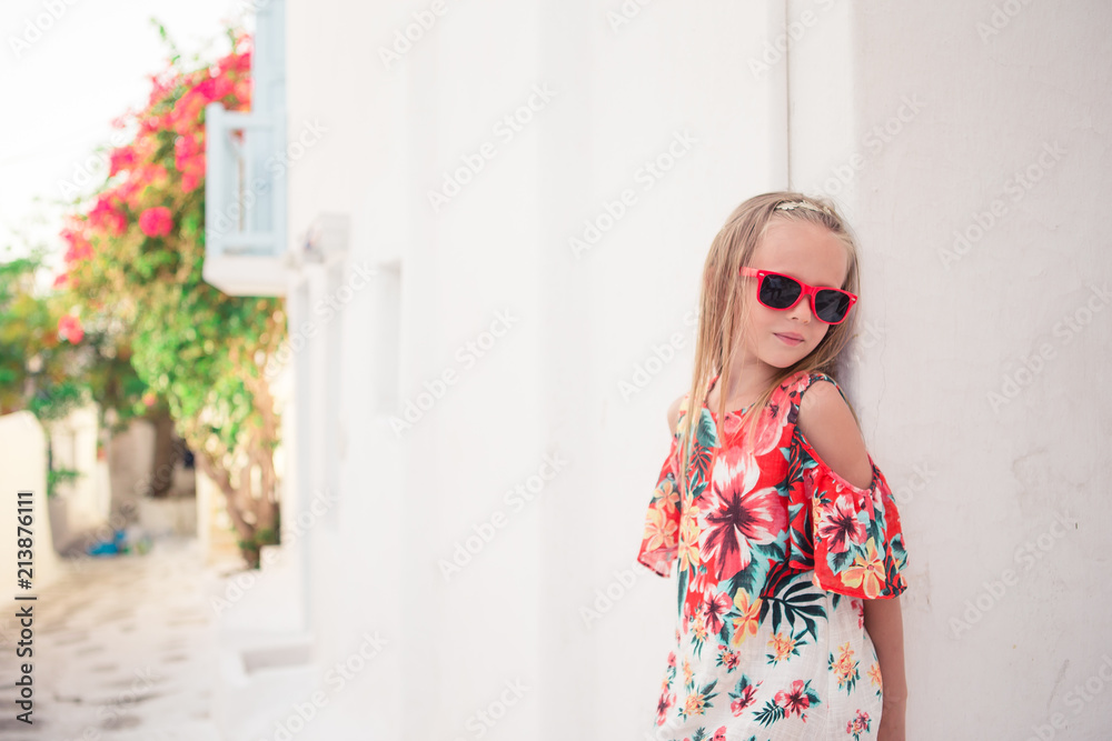 Girl in white dresses having fun outdoors on Mykonos streets