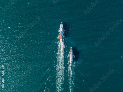top view of two cruise ships in the open sea, one outrunning another