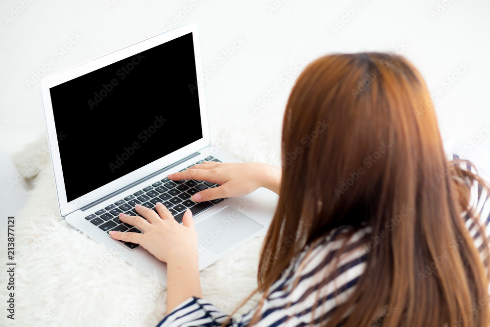 Beautiful asian young woman lying on bed using laptop at bedroom for leisure and relax, freelance with girl working notebook, communication concept, top view.