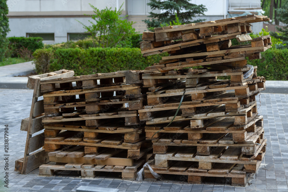 Used wooden euro pallets are stacked at the construction site. Used wooden euro pallets are stacked at the construction site.