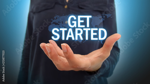 Businesswoman holding get started text over world map